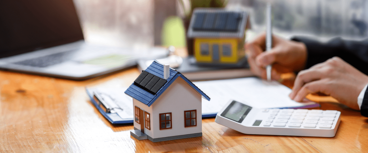 desk with calculator and little model house