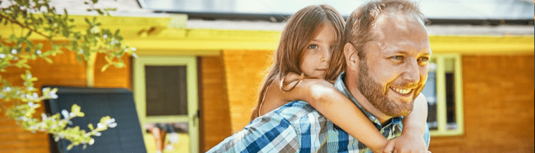 man giving his daughter a piggy back ride