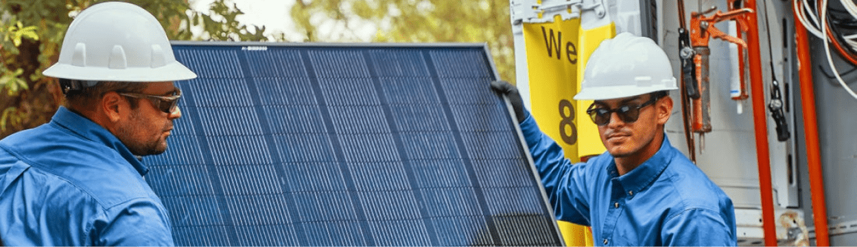 Two installers with hardhats about to begin a residential solar panel installation.